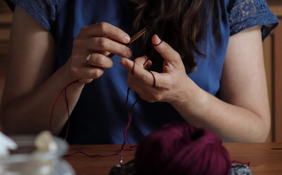 Frau strickt mit Wolle